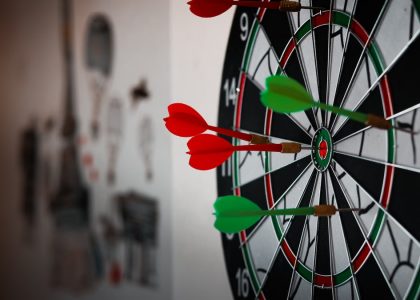 Close-up of a dartboard with multiple darts hitting the target, emphasizing precision and focus.